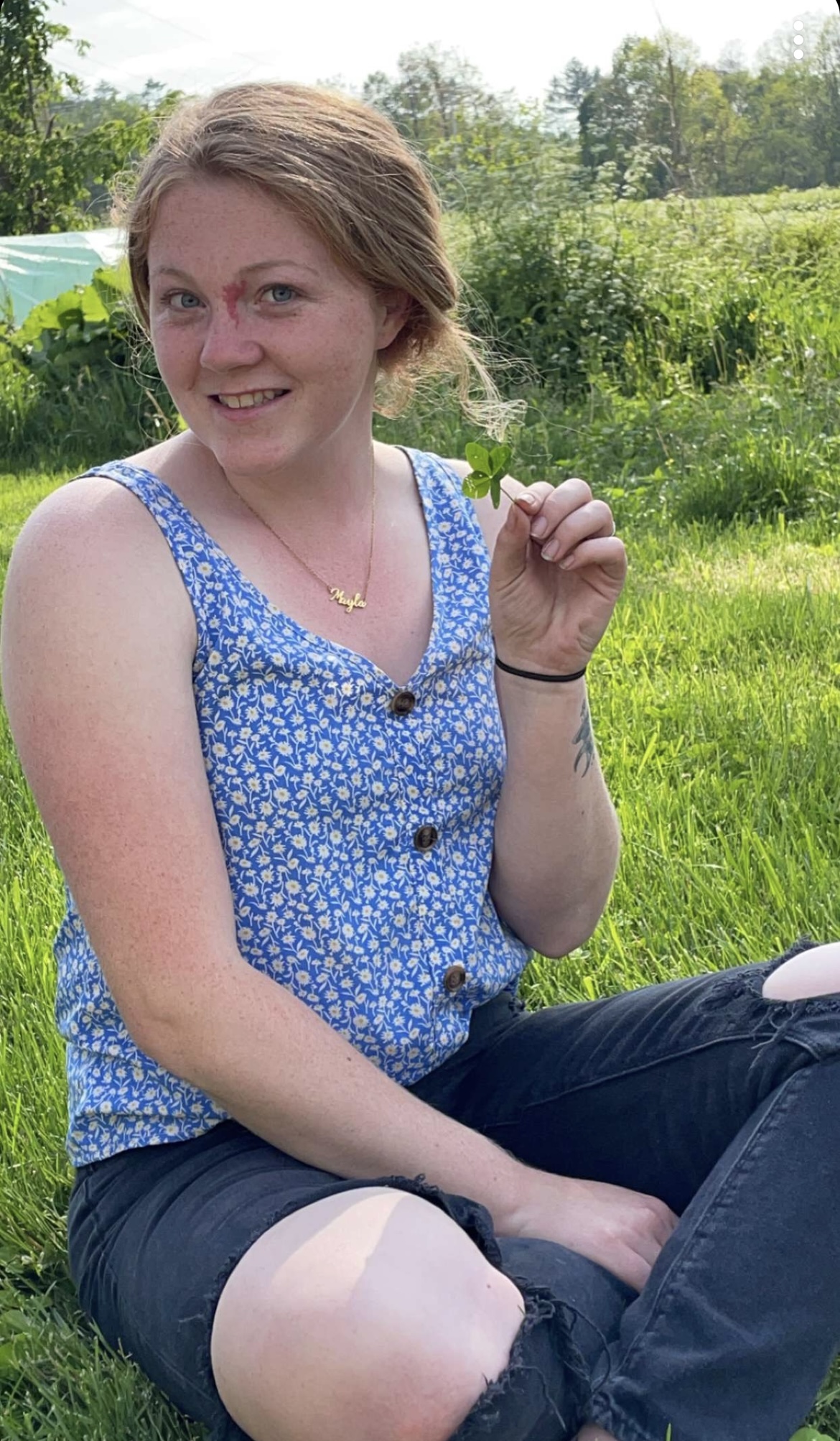 woman in blue sitting in a field